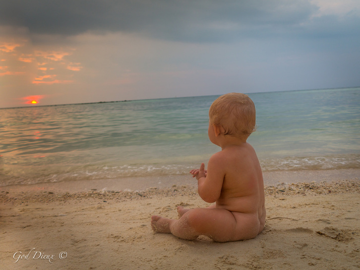 God Dieux Photography ~ baby on beach meditating and in awe at the sunset